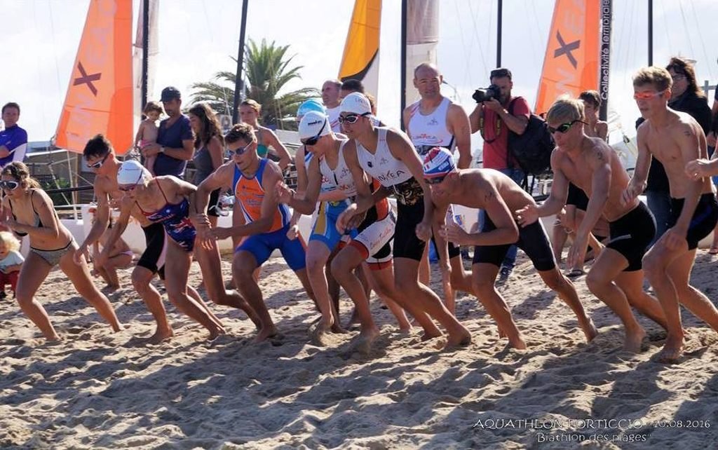 Jeunes triathlètes avec lunettes de natation en train de courrir sur le sable lors d'une manifestation sportive